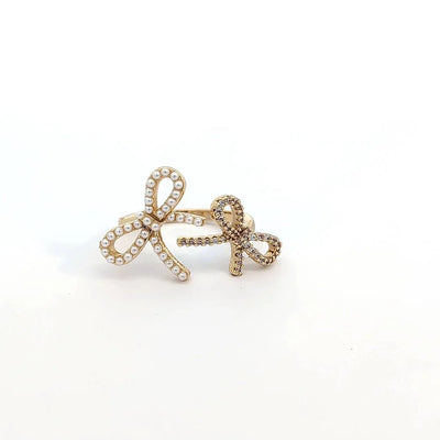 Ring met 2 strikjes afgezet per imitatie pareltjes en strass
