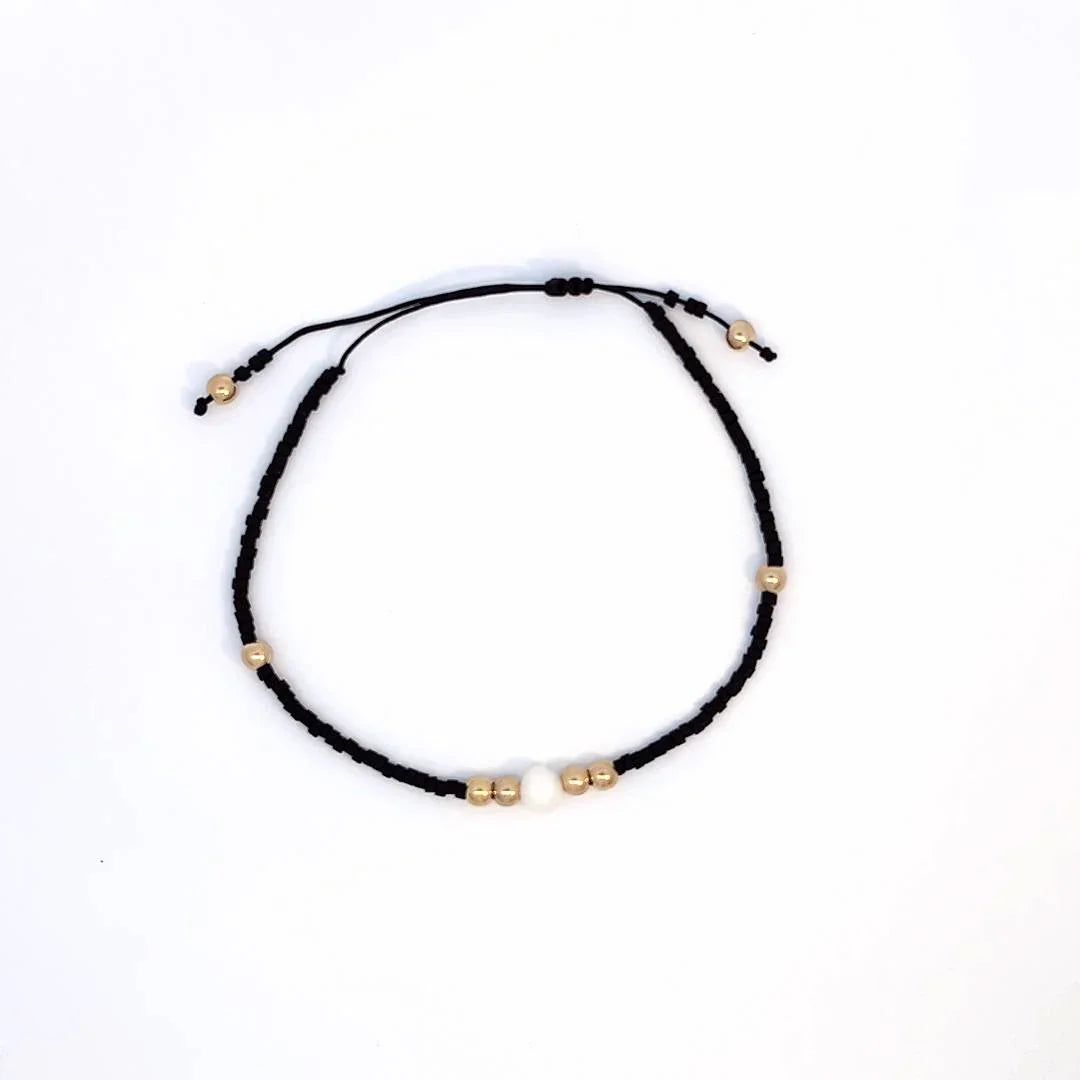 Verstelbare zwarte kleine kraaltjes armband met gouden kraaltjes accent en imitatie parel - Casa Jadel