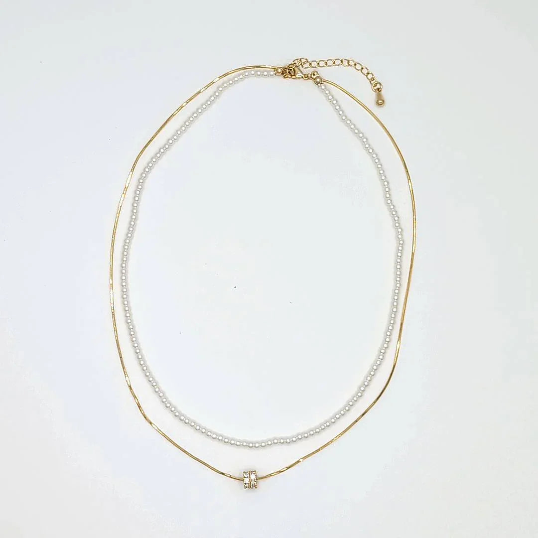 Dubbele gouden ketting met parels en een bedel met strass - Casa Jadel