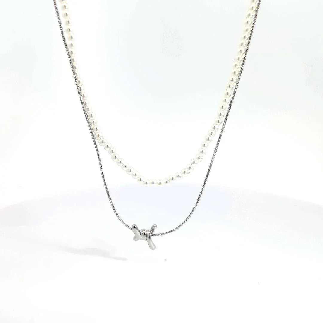 Dubbele zilveren ketting met parelmoer kraaltjes en een prikkeldraad detail - Casa Jadel