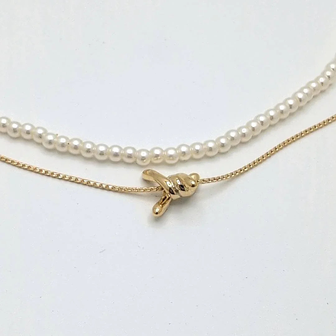 Dubbele gouden ketting met parelmoer kraaltjes en prikkeldraad detail - Casa Jadel