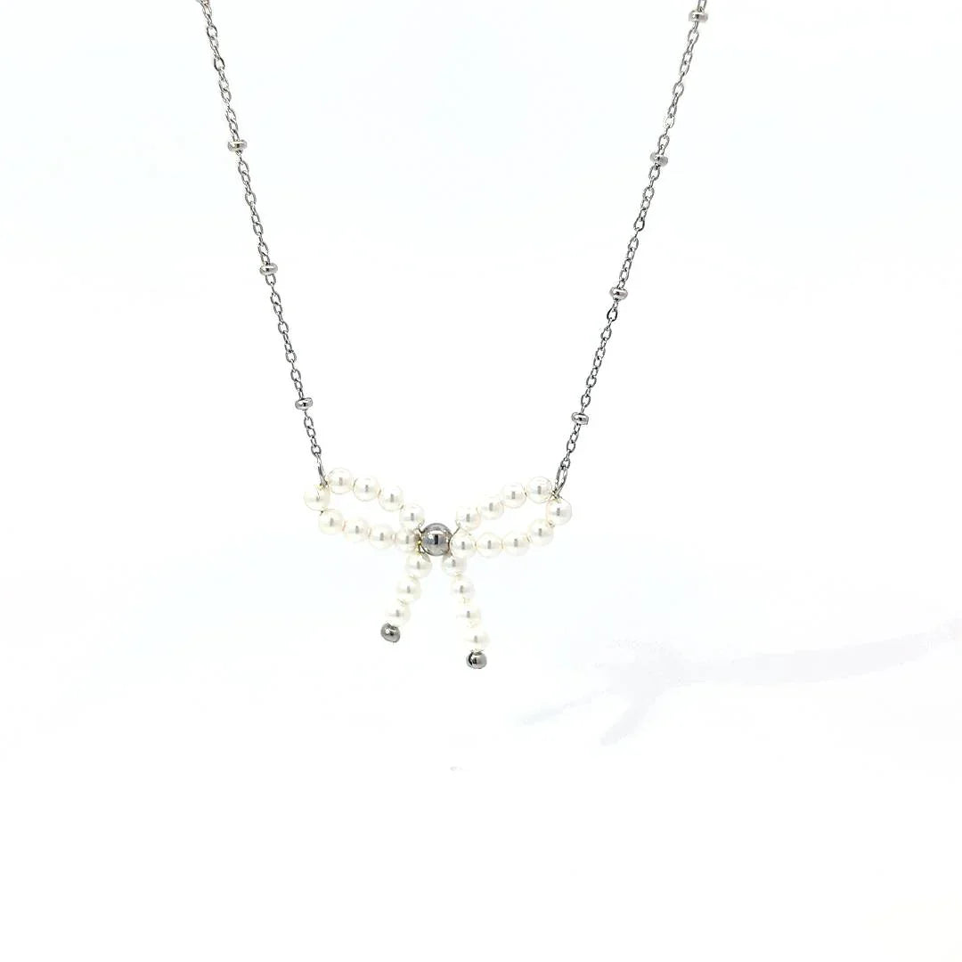 Fijne schakel ketting met balletjes en een parelkraal strik met zilverkleurige details - Casa Jadel