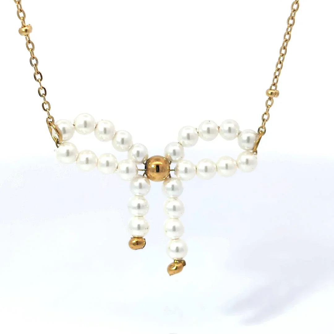 Fijne schakel ketting met balletjes en een parelkraal strik met goudkleurige details - Casa Jadel