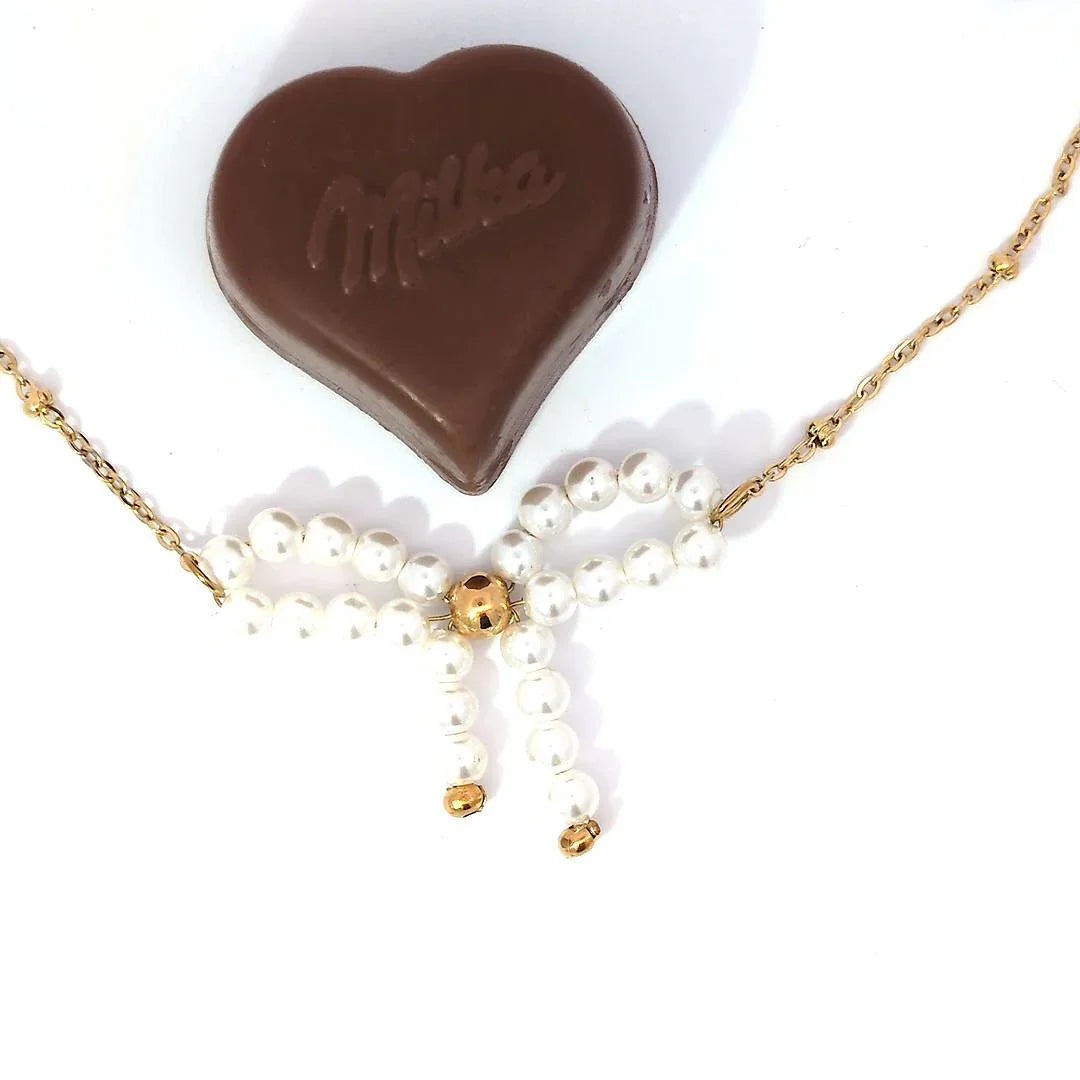 Fijne schakel ketting met balletjes en een parelkraal strik met goudkleurige details - Casa Jadel