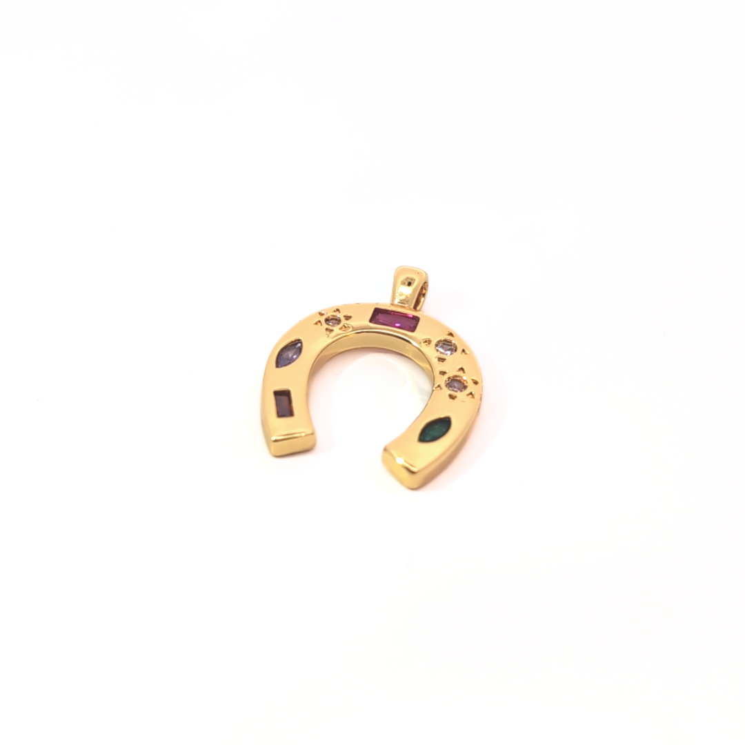 Detail van grote gouden hoefijzer bedel met luxe afwerking en gekleurde steentjes