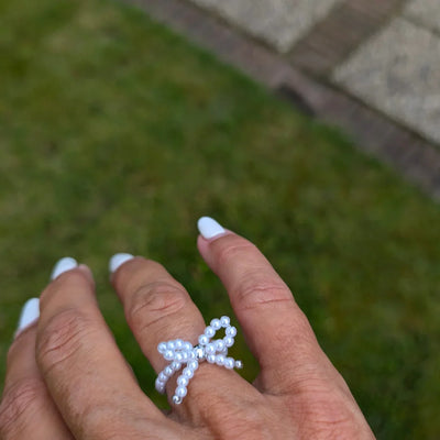 Verstelbare strikjes ring van parel kraaltjes met zilverkleurige details