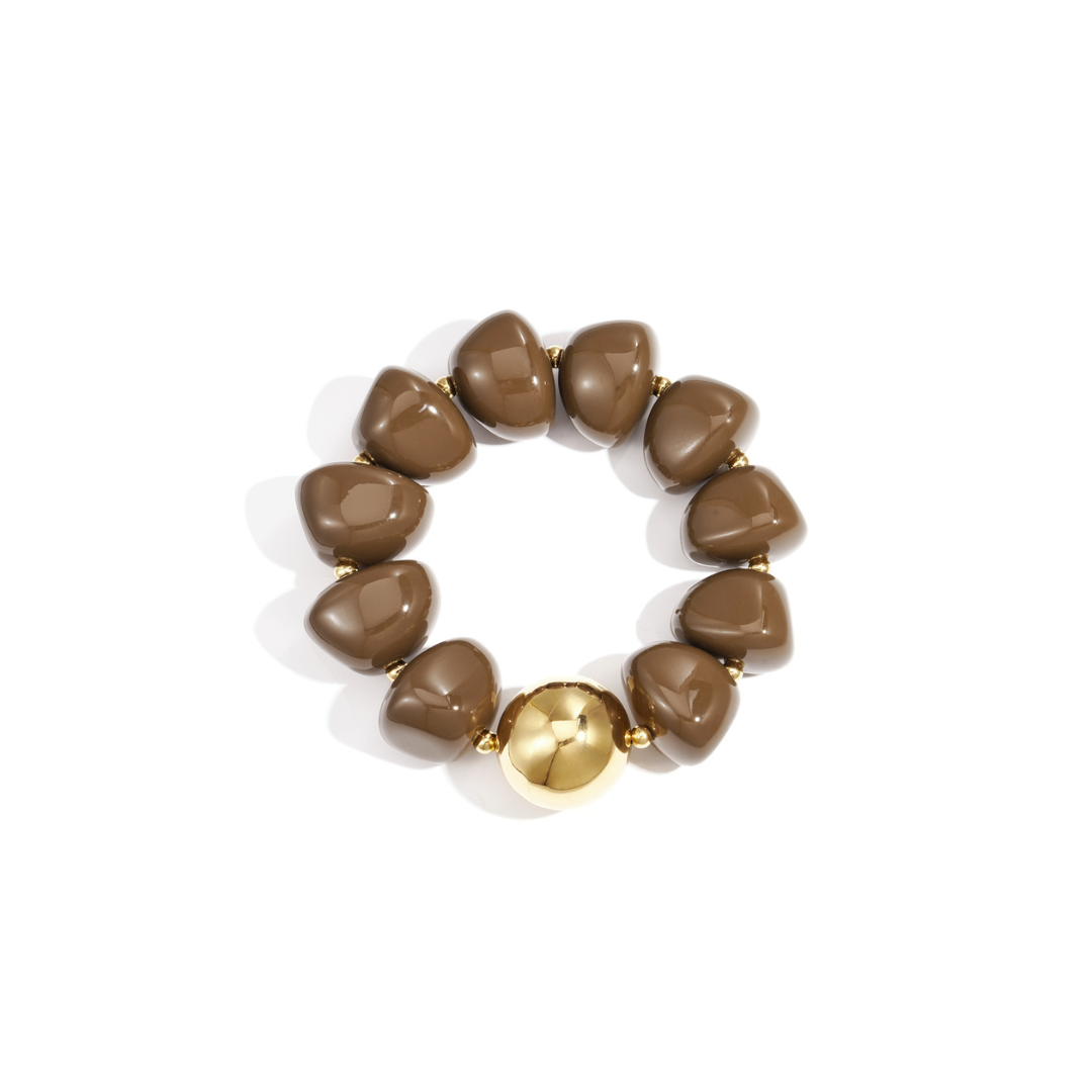 Bruine chunky armband met glanzende mokkabruine kralen en een grote goudkleurige accentkraal.