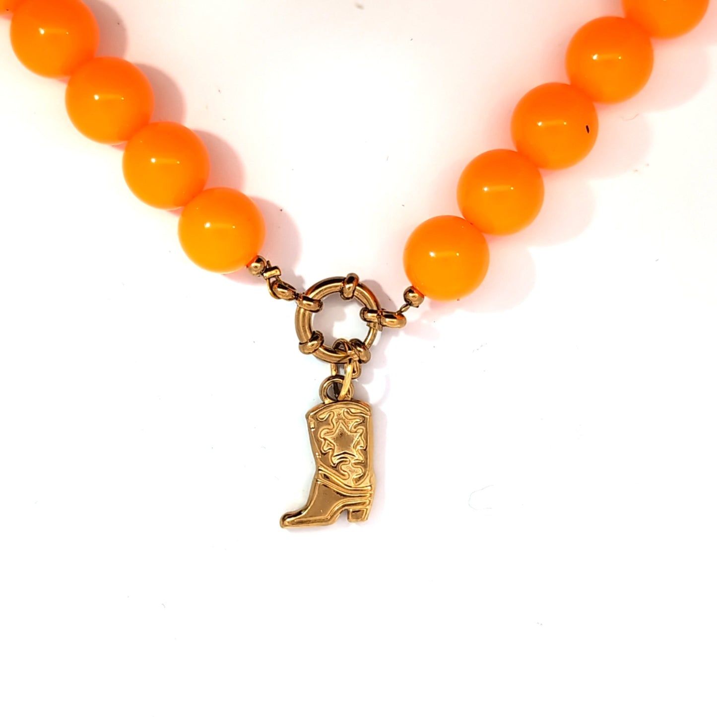 Goudkleurige cowboylaars hanger gedragen aan oranje kralenketting met slotje, speels Jadel sieraad