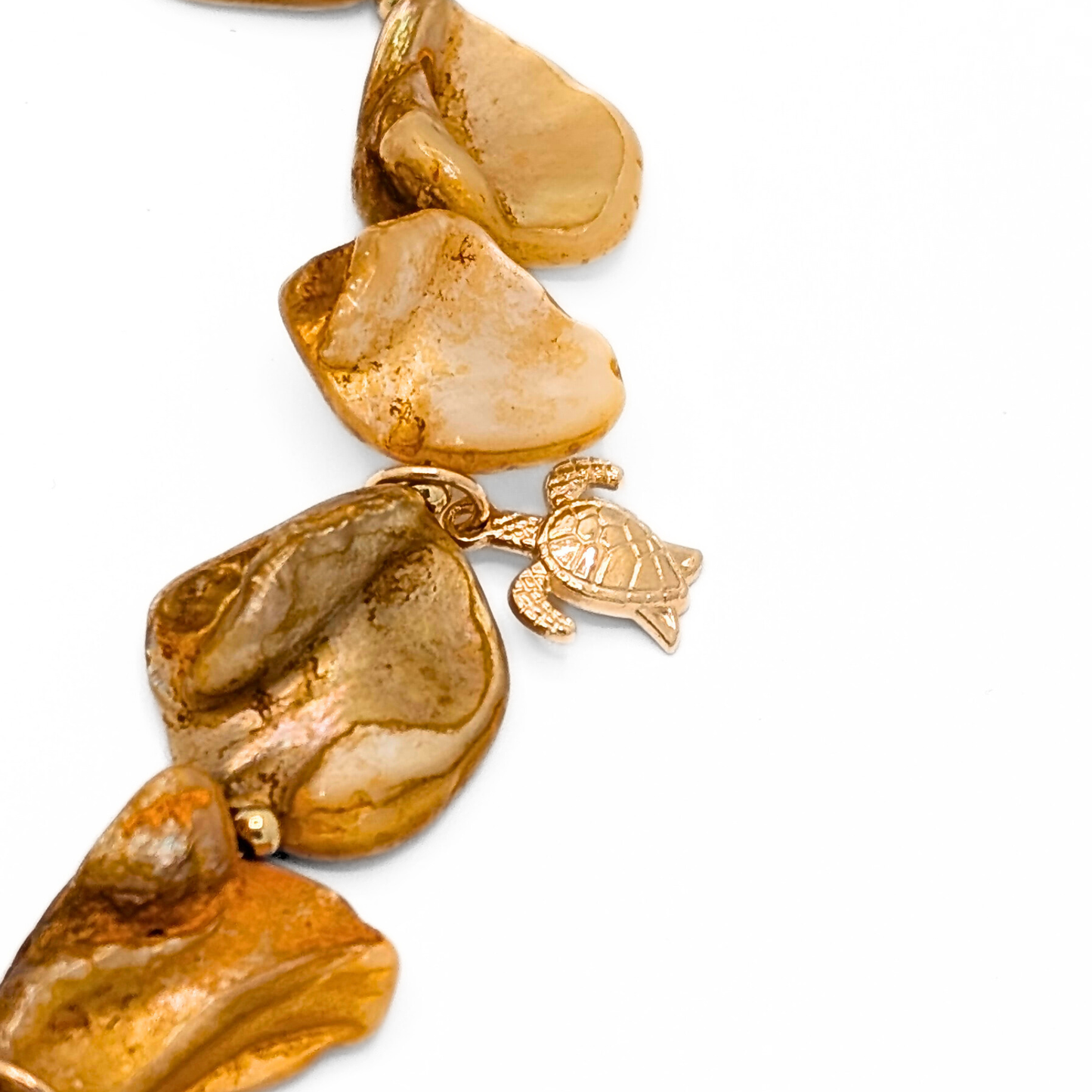 Detail oranje schelpen ketting met gouden zeeschildpad bedel