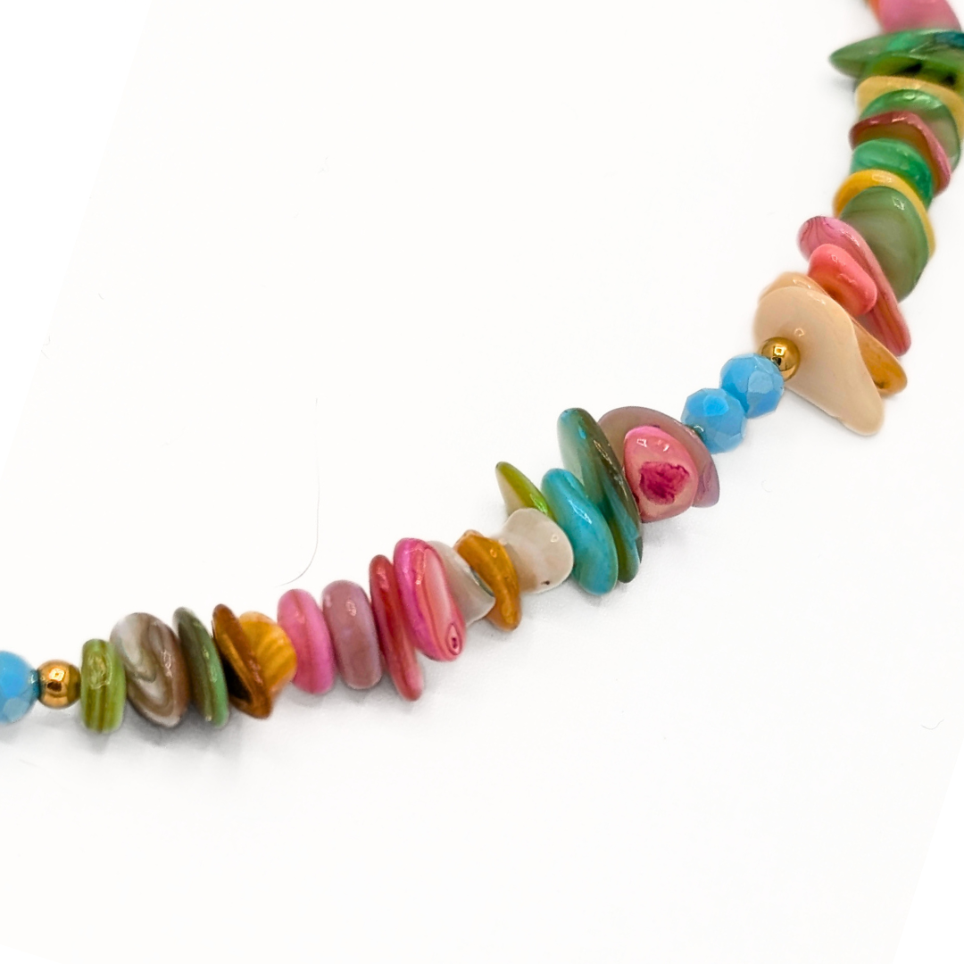 Multicolor schelpen kralenketting met blauwe krab bedel en gekleurde schelpjes. Detail.