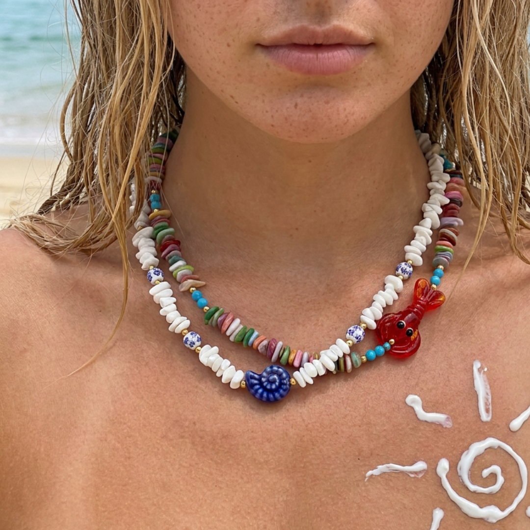 Model draagt dubbele kleurrijke kralenketting met schelpen en rode kreeft bedel van Casa Jadel