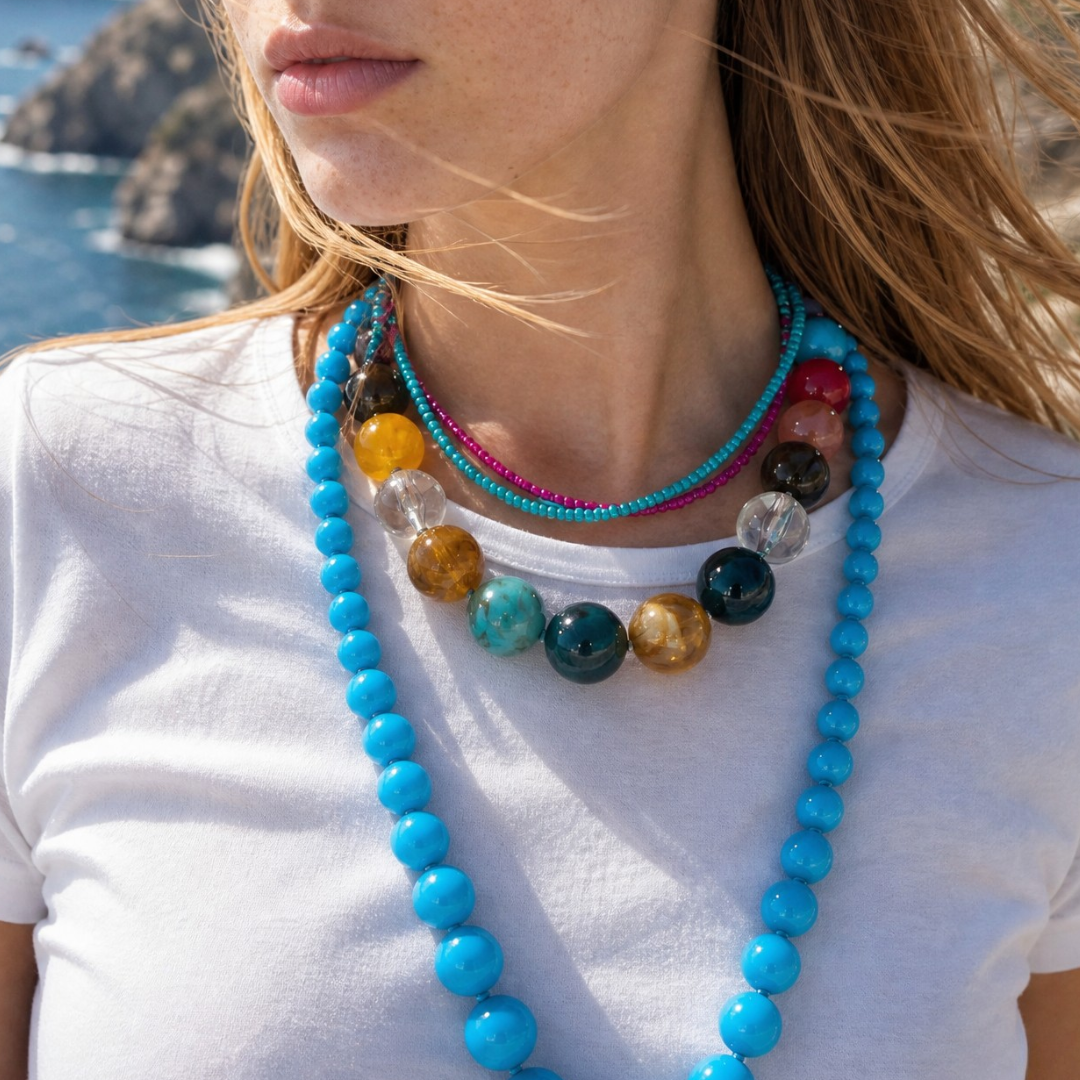 Model draagt set van turquoise, blauwe, roze en natuursteenkralen. Ibiza Style