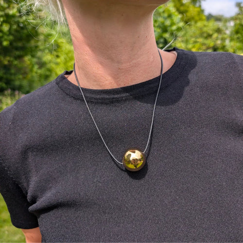 Zwart koord ketting met grote gouden bal