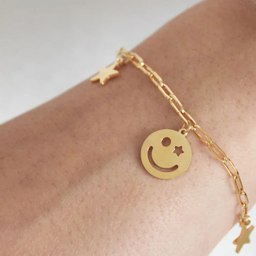 Gouden armband met sterretjes en smileys bedels