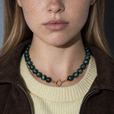 Donkergroen-groene kralenketting met goudkleurig boeislot