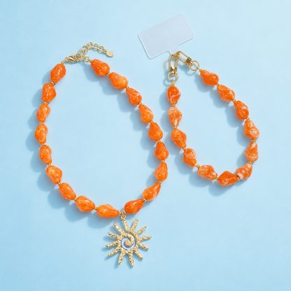 Oranje chunky marble kralenset met zonbedel | ketting en telefoonkoord