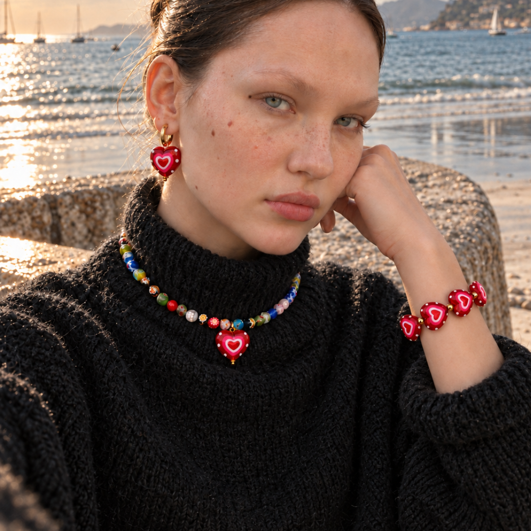 Glazen millefiori kralenketting met hart bedel - gedragen met rode hart oorringetjes en armband aan zee - Casa Jadel