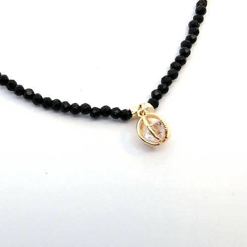 Zwarte kraaltjes ketting met open balletje met een kristal