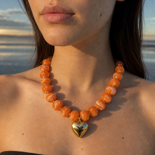 Oranje marble kralenketting met gouden hartbedel gedragen op hals - Casa Jadel statement ketting