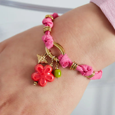 Roze armband van stof met roze bloem gouden bijtje en groene kraal