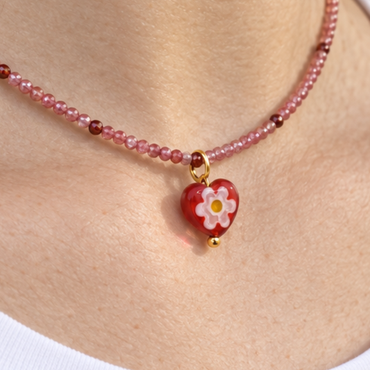 Rode kralenketting met glazen hart hanger met bloemmotief om de hals - Casa Jadel