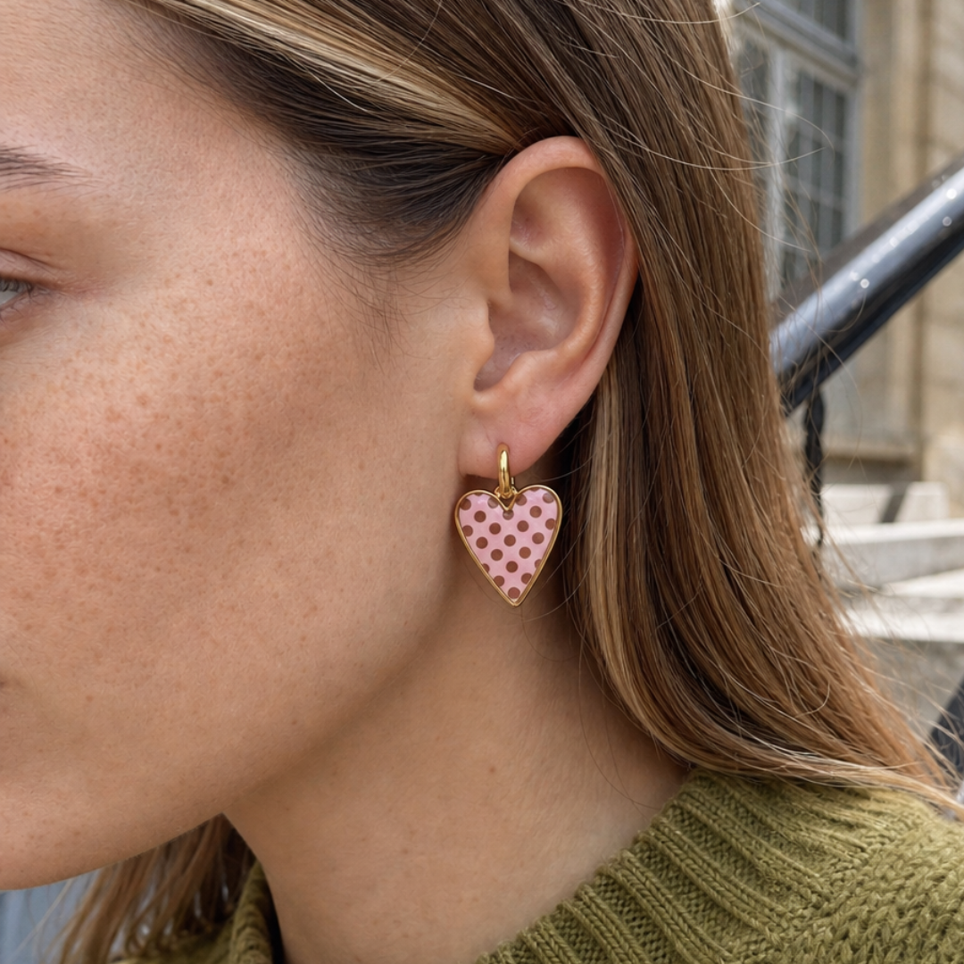 Roze polkadot hartjes oorbellen met gouden creolen gedragen door model
