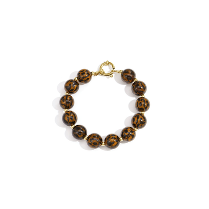 Amber-bruine kralenarmband met panterprint – ronde glanzende kralen met gouden sluiting op witte achtergrond.