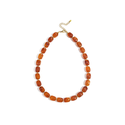 Amberkleurige kralenketting met glanzende transparante kralen en goudkleurige sluiting.