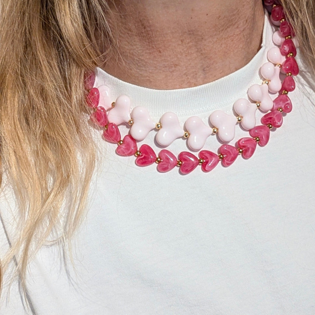 Baby roze hartjes en fuchsia hartjes  kralenketting met gouden details op model
