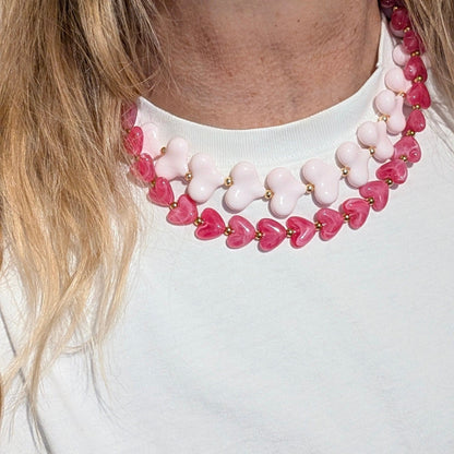 Baby roze hartjes en fuchsia hartjes  kralenketting met gouden details op model