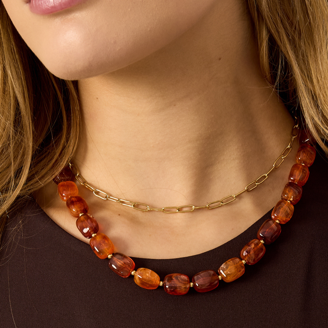 Bordeauxrode kralenketting met glanzende organische kralen en goudkleurige tussenkraaltjes.