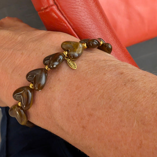 Bruine hartjes kralenarmband op een arm