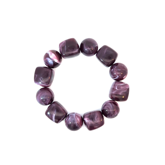 Chunky kralenarmband met grote ronde en vierkante kralen in aubergine en paars tinten, Ibiza style armband op witte achtergrond.