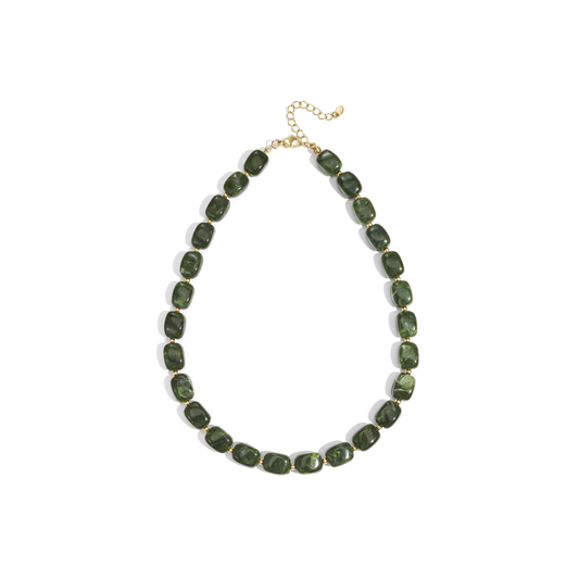 Donkergroene kralenketting met glanzende organische kralen en goudkleurige tussenkraaltjes.
