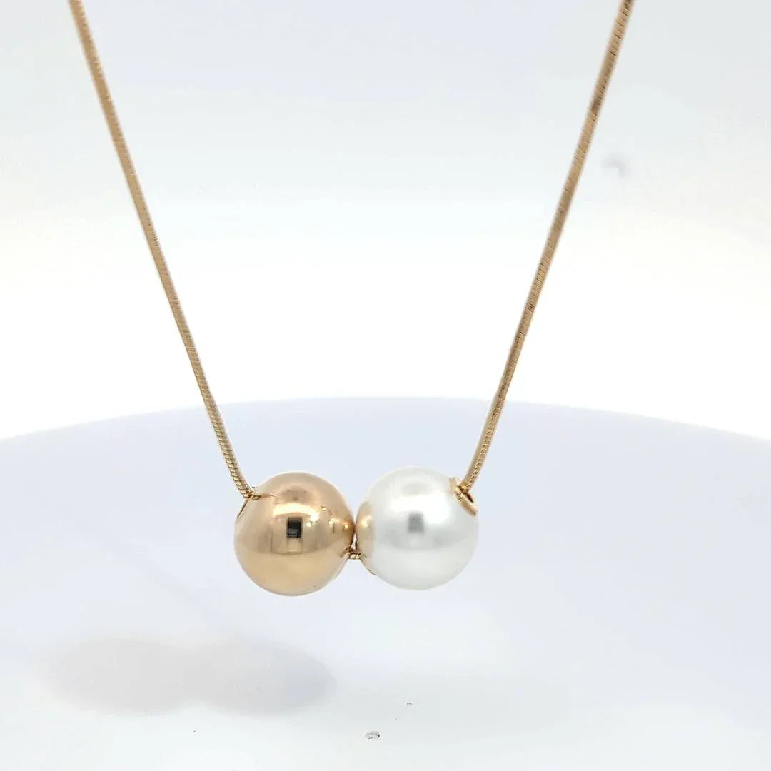 Dunne gouden ketting met witte en parelmoer kleurige bal - Casa Jadel