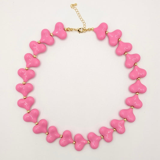Felroze hartenketting met glanzende hartkralen en goudkleurige tussenkraaltjes.