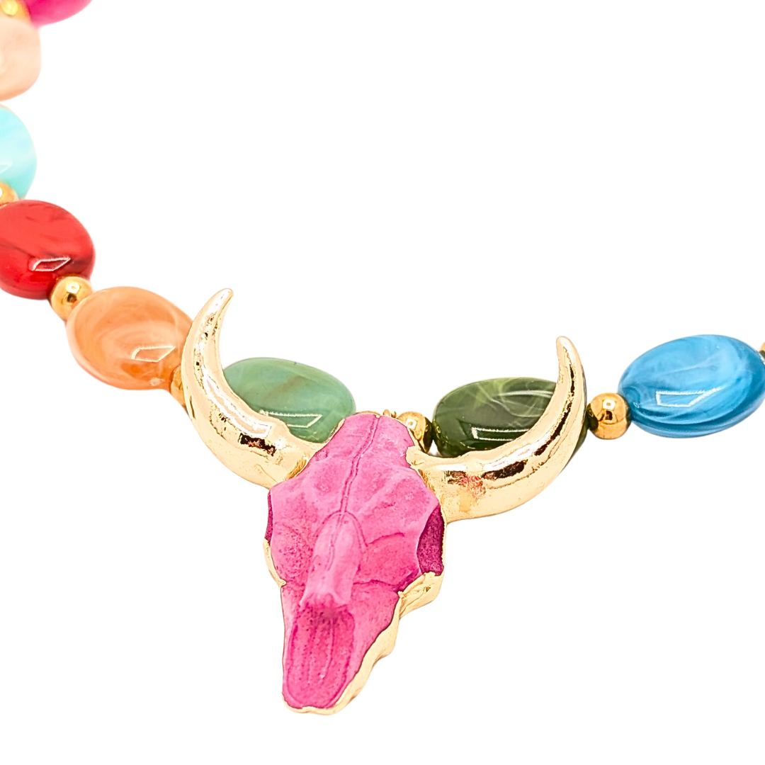 Close-up van kleurrijke kralenketting met gouden longhorn bedel en roze buffelschedel