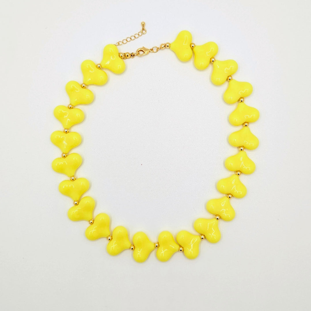 Gele hartenketting met glanzende hartkralen en goudkleurige tussenkraaltjes.