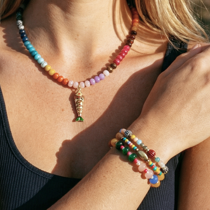 Model draagt glazen kralenketting met oranje vis bedel en Ada armbanden set Casa Jadel