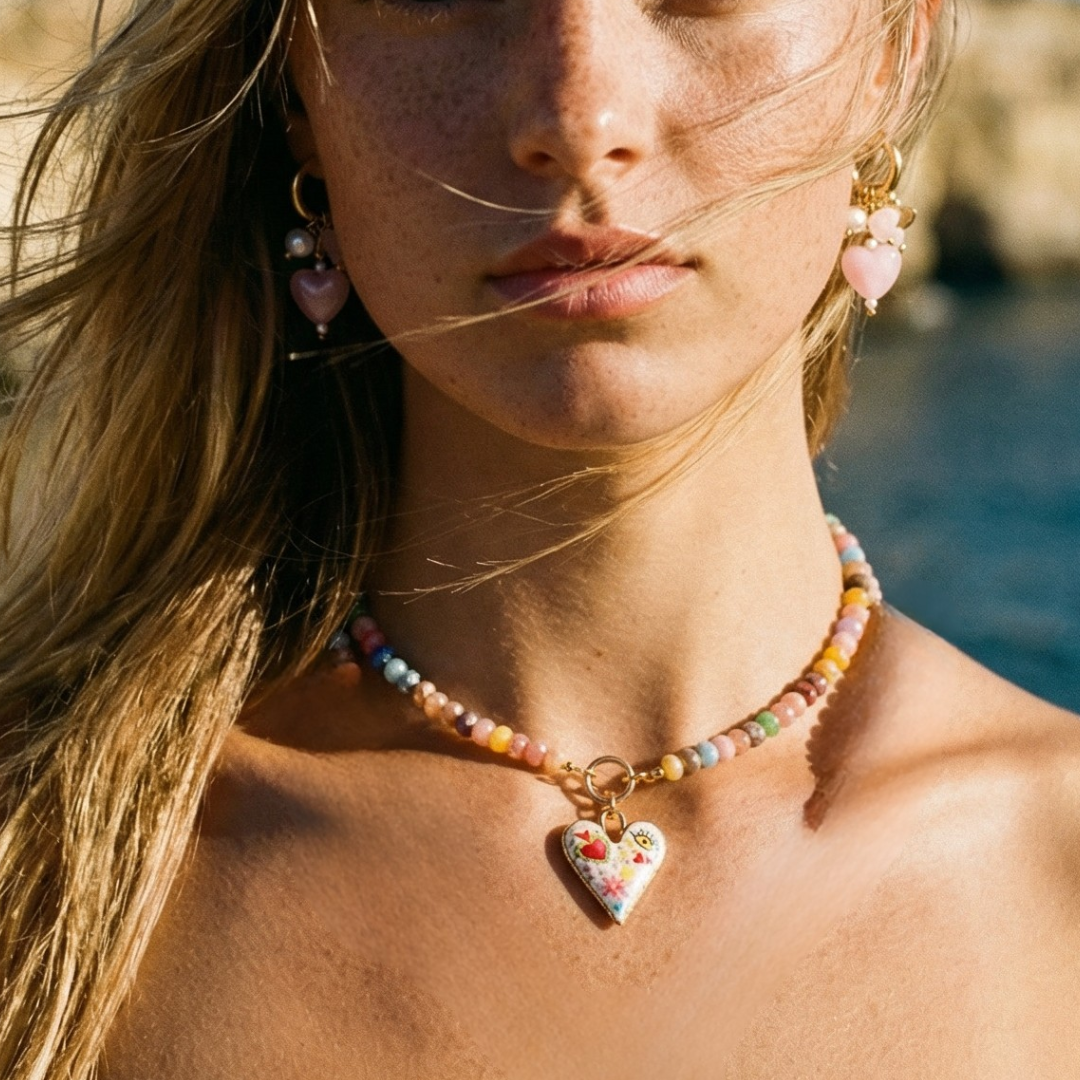 Model draagt glazen kralenketting met bijpassende parelmoer roze oorringetjes.