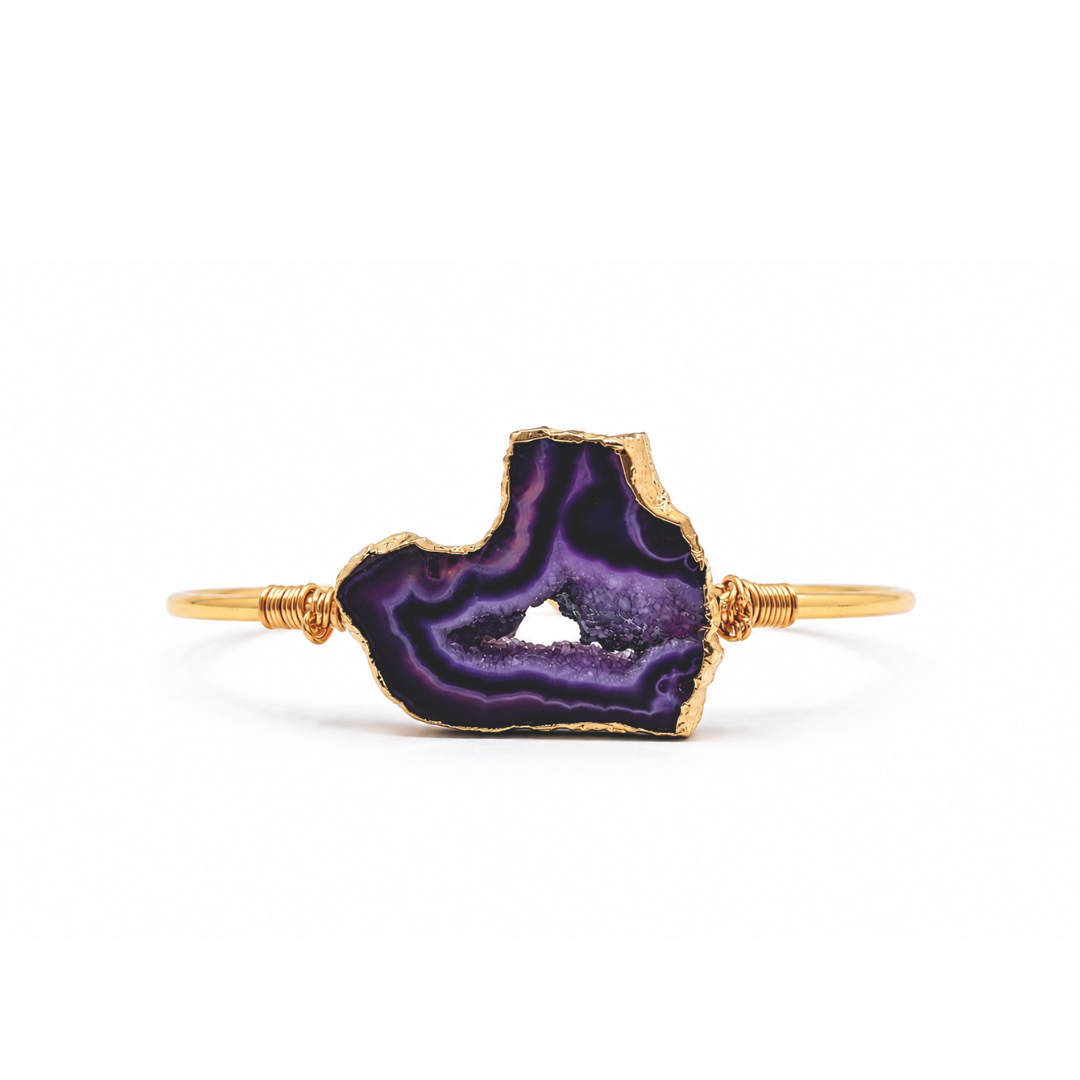Gouden bangle met paarse amethist natuursteen en luxe goudkleurige afwerking op witte achtergrond