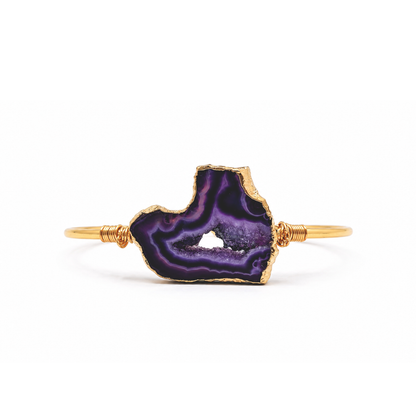 Gouden bangle met paarse amethist natuursteen en luxe goudkleurige afwerking op witte achtergrond