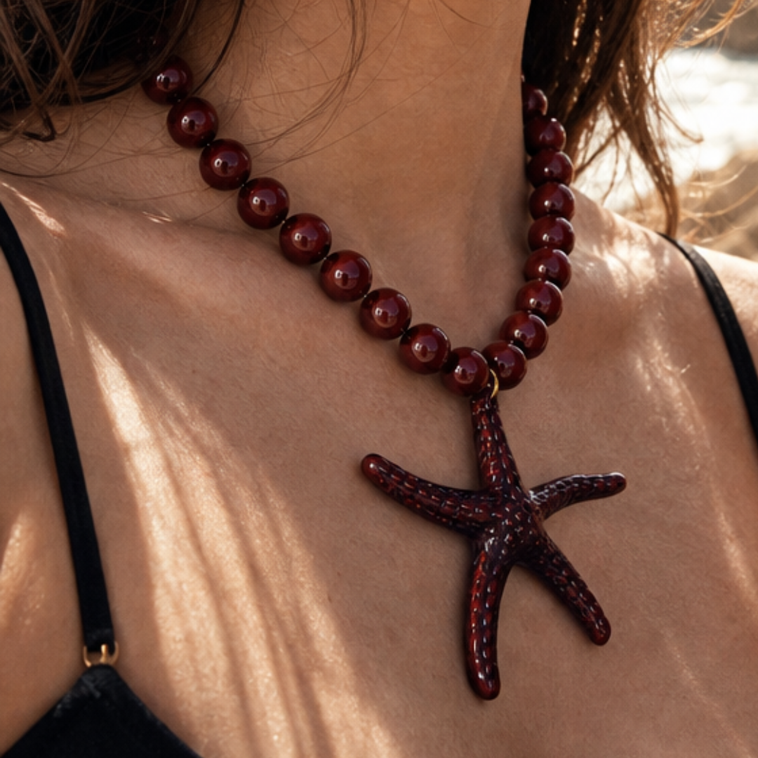 Grote kralenketting met oversized statement zeester bedel gedragen in bruin-burgundy