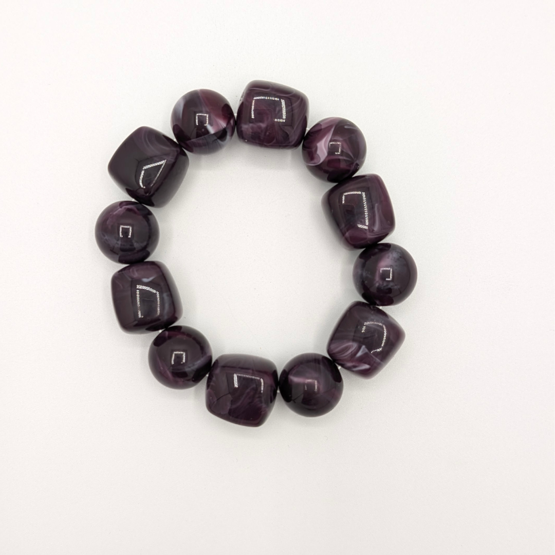 Paarse chunky armband met glanzende ronde en vierkante kralen in donkerpaarse tint.