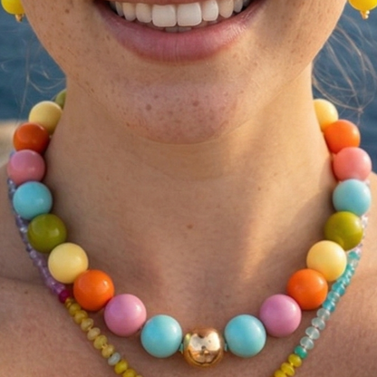 Model draagr grote kralenketting - kleurrijk, zomer - met gouden kraal. Ibiza Style