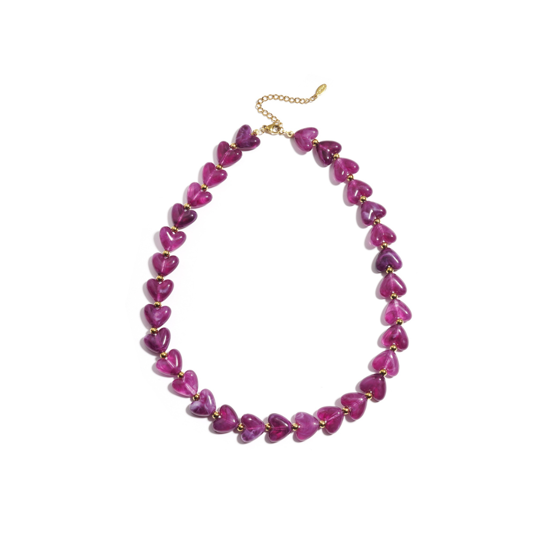 Paarse hartjes kralenketting met transparante hartvormige kralen en goudkleurige details.