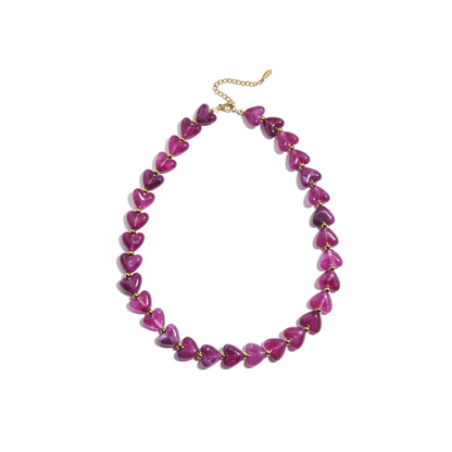 Paarse hartjes kralenketting met transparante hartvormige kralen en goudkleurige details.