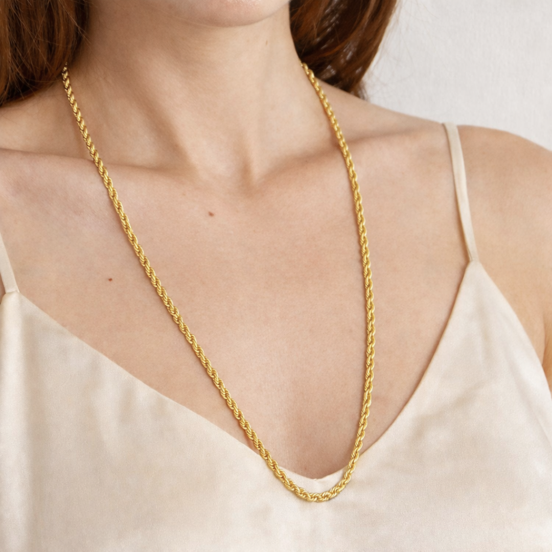 Lange gouden gedraaide ketting S van stainless steel gedragen om de hals