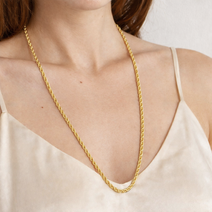Lange gouden gedraaide ketting S van stainless steel gedragen om de hals