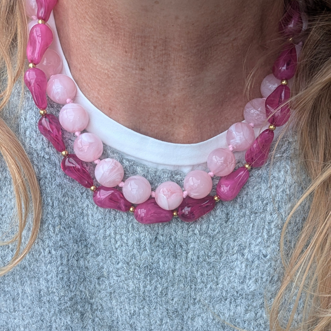 MODEL MET ROZE GEMARMERDE GROTE KRALENKETTING EN CHUNKY FUCHSIA ROZE GROTE KRALENKETTING